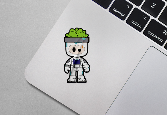 A vibrant sticker featuring the “Pott•o” character, depicted as a cute astronaut-inspired pot-headed figure with a succulent plant on its head. The sticker is placed on the corner of a silver laptop, enhancing its aesthetic with a playful and futuristic vibe.